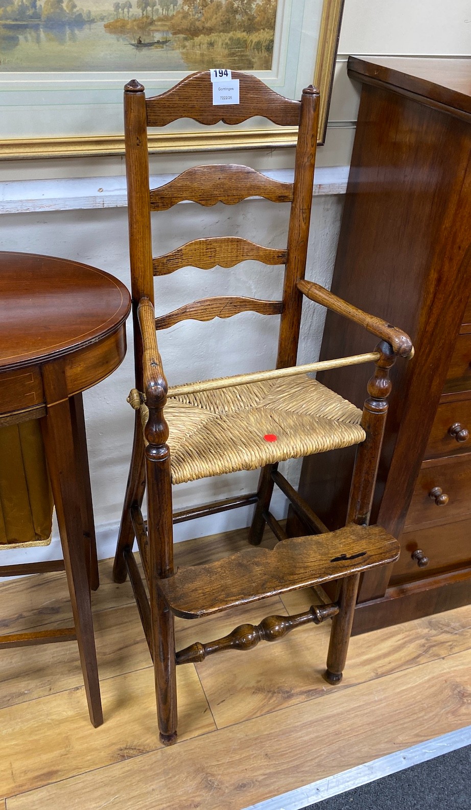 An early 19th century ash and elm ladder back rush seat child's high chair, height 104cm